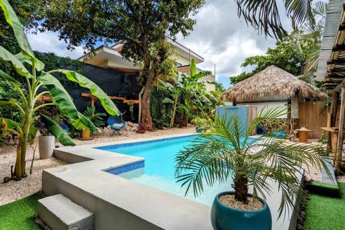 una piscina con una palmera en un patio en Matambú Rancho Rustic 2bd Apt with Shared Pool, en Matapalo