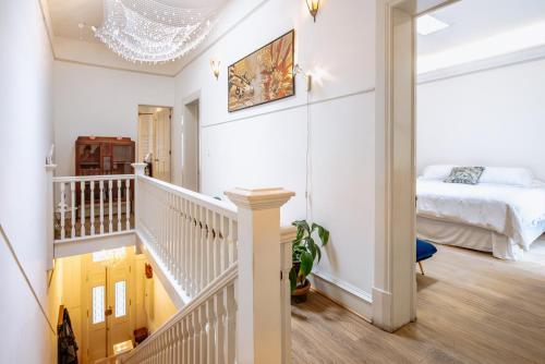 Habitación blanca con cama y escalera en Casa Chapulín-Mexican Eclectic Home in Roma Norte, en Ciudad de México