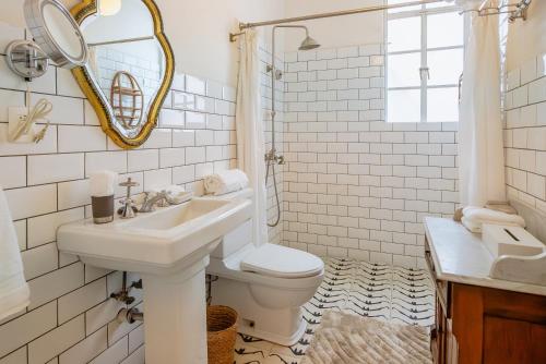 Un baño con lavabo, inodoro y espejo. en Casa Chapulín-Mexican Eclectic Home in Roma Norte, en Ciudad de México