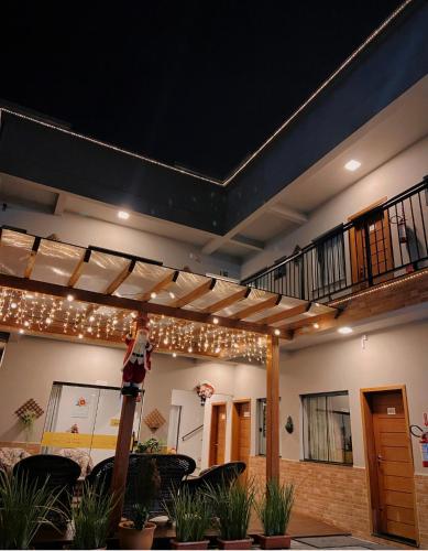 a patio with a deck with lights and chairs at Pousada Villa Vantino in Penha