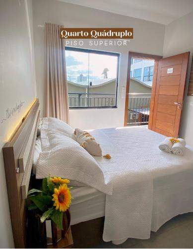 a bedroom with a large white bed with towels on it at Pousada Villa Vantino in Penha