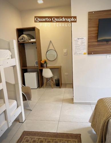 a room with a bunk bed and a tv on a wall at Pousada Villa Vantino in Penha