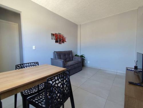 a living room with a table and a couch at Charmoso ap em Sete lagoas in Sete Lagoas