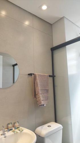 a bathroom with a toilet and a sink and a mirror at Charmoso ap em Sete lagoas in Sete Lagoas