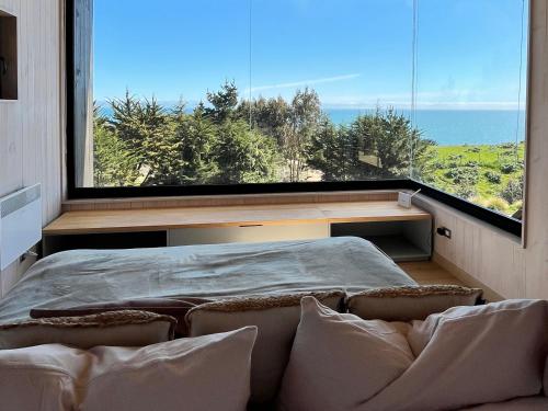 a bedroom with a bed and a large window at Chackra Centinela in Navidad