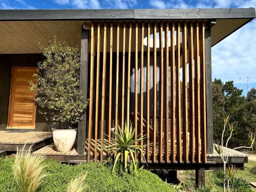 a small house with a wooden wall at Chackra Centinela in Navidad