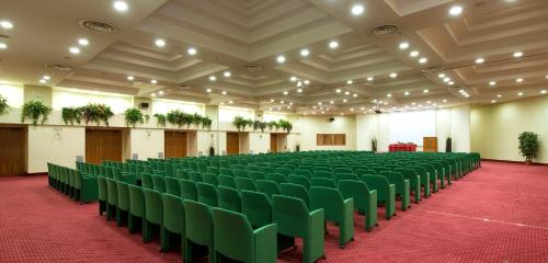 a large room with green chairs and a red carpet at Grand Hotel Barone Di Sassj in Sesto San Giovanni