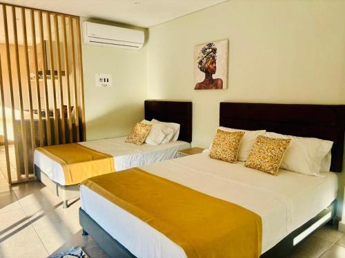 a hotel room with two beds and a window at Hotel Payara Puerto Gaitán in Puerto Gaitán