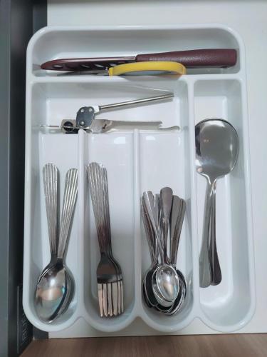 a white tray filled with silver utensils at Village Vibes at Splashmania Gamuda Cove in Pulau Kempas