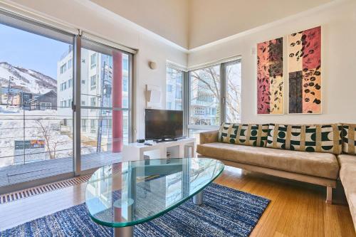 a living room with a couch and a glass table at Niseko Central Condominiums in Kutchan