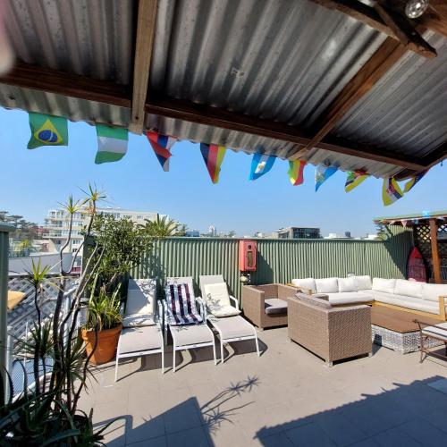 a patio with couches and chairs under a metal roof at Boardrider Backpackers and Budget Motel in Sydney