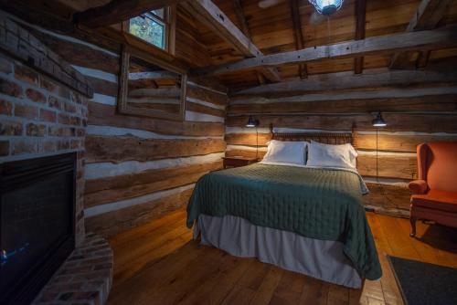 a bedroom with a bed in a log cabin at Moore House Inn & Cabins in Marlinton