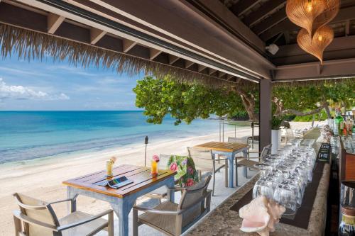 a restaurant on the beach with tables and chairs at The Buccaneer Beach & Golf Resort in Christiansted