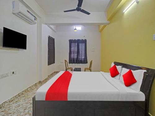 a bedroom with a large bed with red pillows at Hotel O ROYAL STAY in Haidar Sāhibgūda