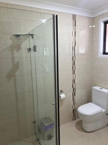Un baño con inodoro y ducha de cristal. en Luxurious Home, en Oakhurst