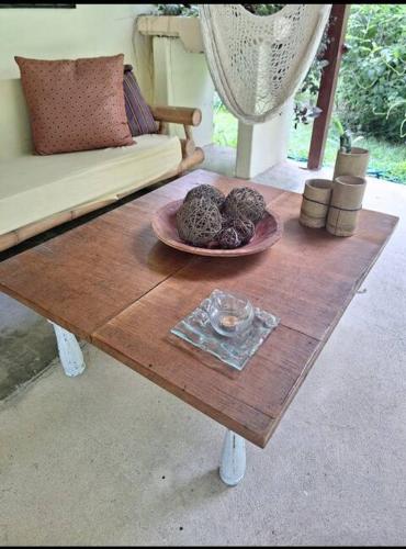 a wooden coffee table with a plate of food on it at Four Monkeys Eco Lodge Jungle & Beach - The House in Cabo Matapalo