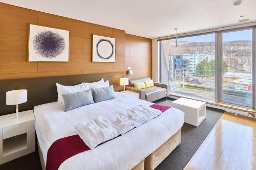 a bedroom with a large bed and a large window at Niseko Central Condominiums in Kutchan