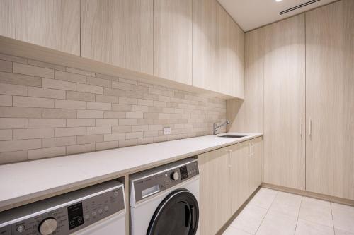 a laundry room with a washer and dryer at Santorini Blue Sorrento with heated spa and stunning views in Sorrento