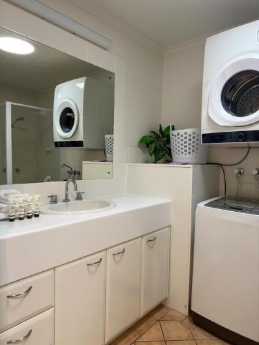 a white bathroom with a sink and a microwave at Central Noosa location, Noosa Heads in Noosa Heads