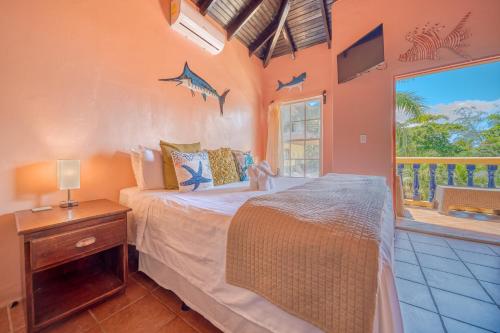a bedroom with a bed and a window with sharks on the wall at Caribe Tesoro in West Bay