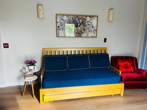 a bed and a red chair in a room at Piemonte Flat Serra Negra in Serra Negra