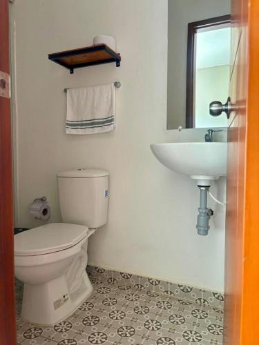a bathroom with a toilet and a sink at Hotel Payara Puerto Gaitán in Puerto Gaitán
