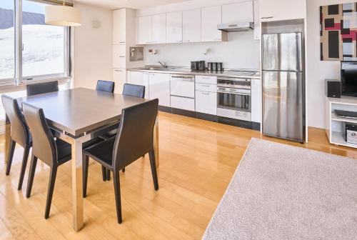 a kitchen with a dining room table and chairs at Niseko Central Condominiums in Kutchan