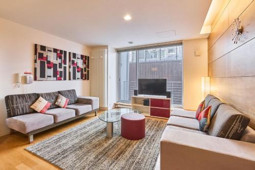 a living room with two couches and a television at Niseko Central Condominiums in Kutchan