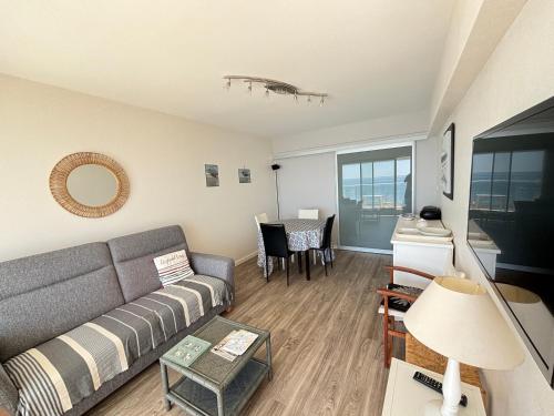 un salon avec un canapé et une table dans l'établissement Appartement T2 avec balcon face mer - FR-1-197-132, à Les Sables-dʼOlonne