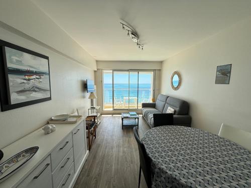 une chambre avec un lit et un salon avec un canapé dans l'établissement Appartement T2 avec balcon face mer - FR-1-197-132, à Les Sables-dʼOlonne