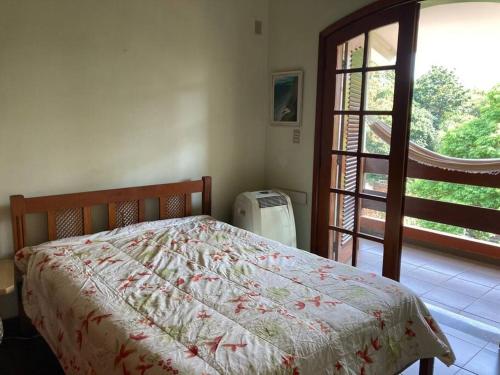 a bedroom with a bed and a large window at Casa grande, ampla, com 4 quartos e estacionamento in Ribeirão Preto