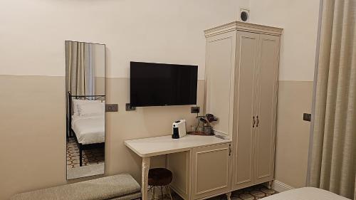 a bathroom with a sink and a tv on a wall at כוהנ'ס Cohen's Boutique Hotel in Haifa
