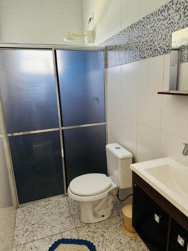 a bathroom with a toilet and a shower and a sink at Chacara com Piscina em Suzano completa in Suzano