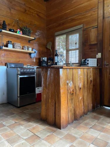 a kitchen with a wooden counter and a stove at PROVENZA en Los Naranjos in Juayúa