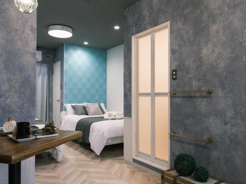a bedroom with a bed and blue walls at Tsubame INN Nipponbashi in Osaka