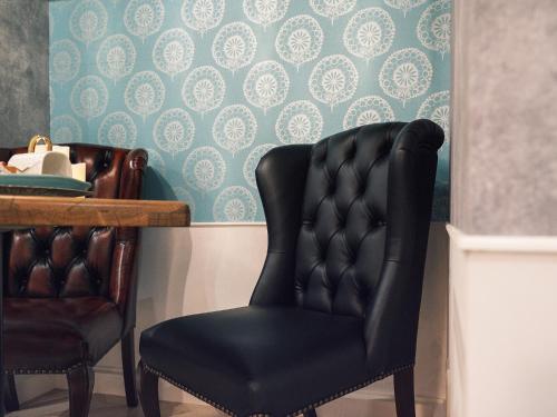 a dining room with a black chair and a table at Tsubame INN Nipponbashi in Osaka