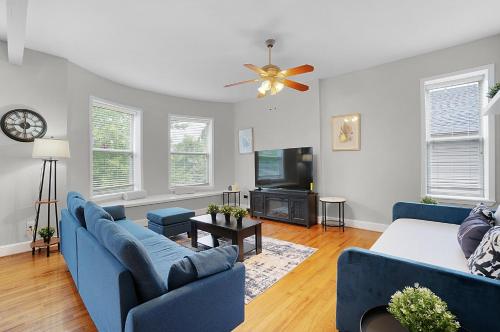a living room with blue couches and a tv at Spacious 3-Bedroom with King Bed & Prime Location in Tower Grove