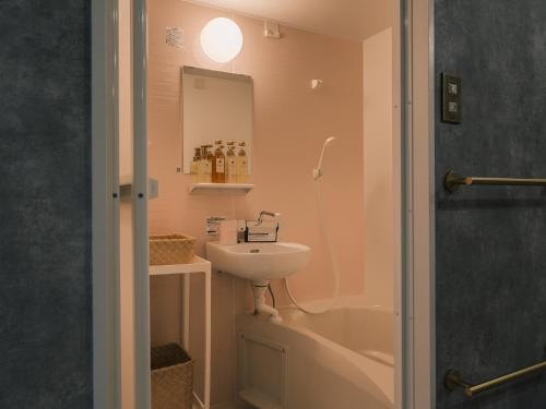 a bathroom with a sink and a toilet and a mirror at Tsubame INN Nipponbashi in Osaka