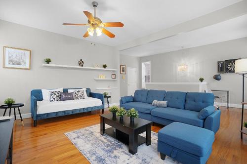 a living room with blue couches and a ceiling fan at Spacious 3-Bedroom with King Bed & Prime Location in Tower Grove