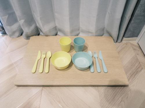 a table with forks and cups and utensils on it at Tsubame INN Nipponbashi in Osaka