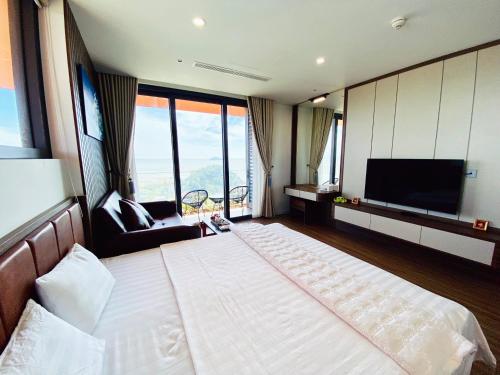 a bedroom with a large bed and a television at Flamingo Hai Tien in Hoằng Hóa