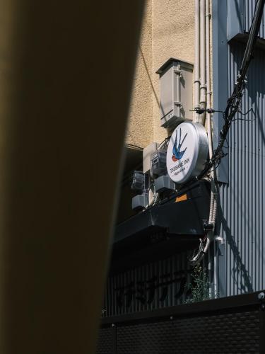 a clock on the side of a building at Tsubame INN Nipponbashi in Osaka
