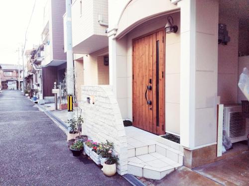 a building with a wooden door on the side of a street at Kishisato Japanese House QB-1 in Osaka