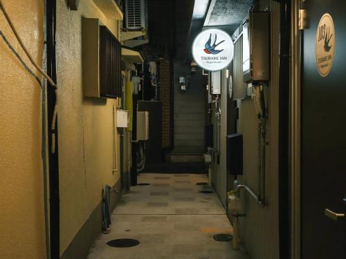 an alley way with a sign on the side of a building at Tsubame INN Nipponbashi in Osaka