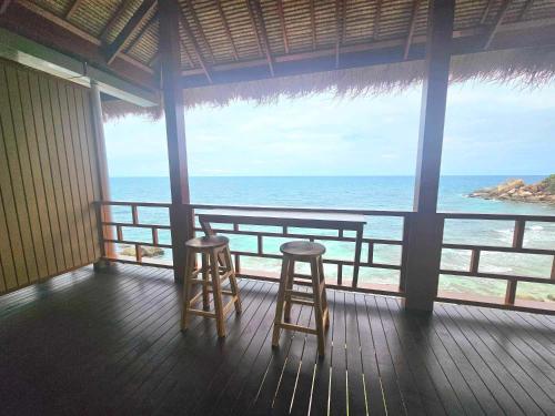 two stools on a porch looking out at the ocean at Tao Thong Villa 2 in Ko Tao