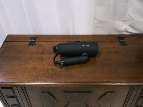 a hair dryer sitting on top of a wooden table at Tsubame INN Nipponbashi in Osaka