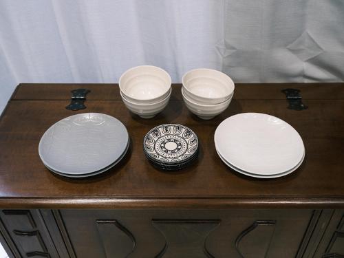 four white plates and bowls on a wooden table at Tsubame INN Nipponbashi in Osaka