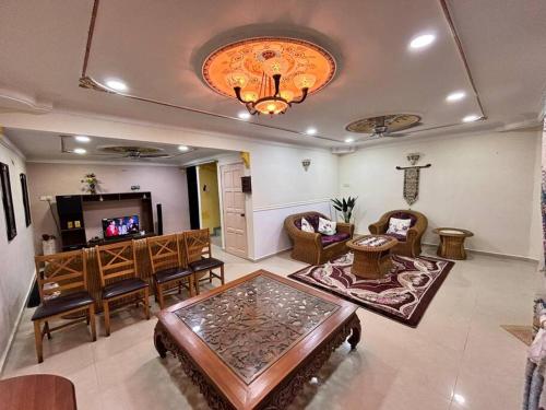 a living room with chairs and a table and a television at Kurma & Manggis Homestay 5BR in Paya Rumput
