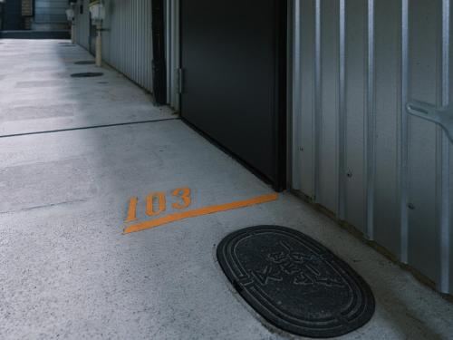 an orange line is next to a black object on the floor at Tsubame INN Nipponbashi in Osaka