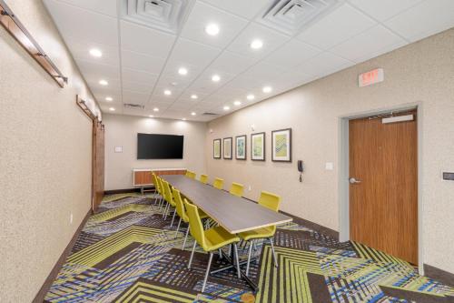 a conference room with a long table and yellow chairs at Holiday Inn Express & Suites - Lindale by IHG in Lindale